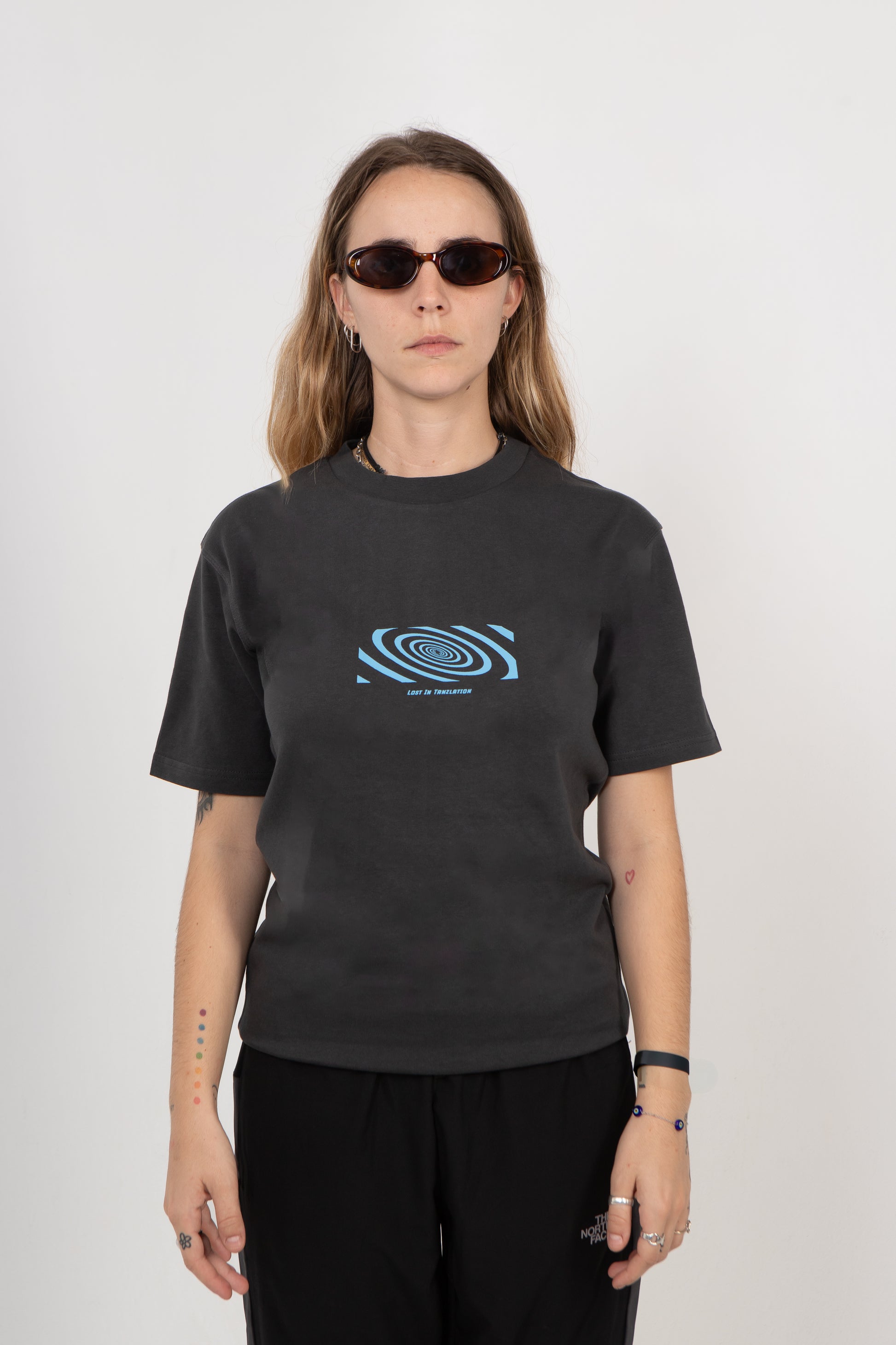 Person wearing a black t-shirt with a blue spiral design on a white background