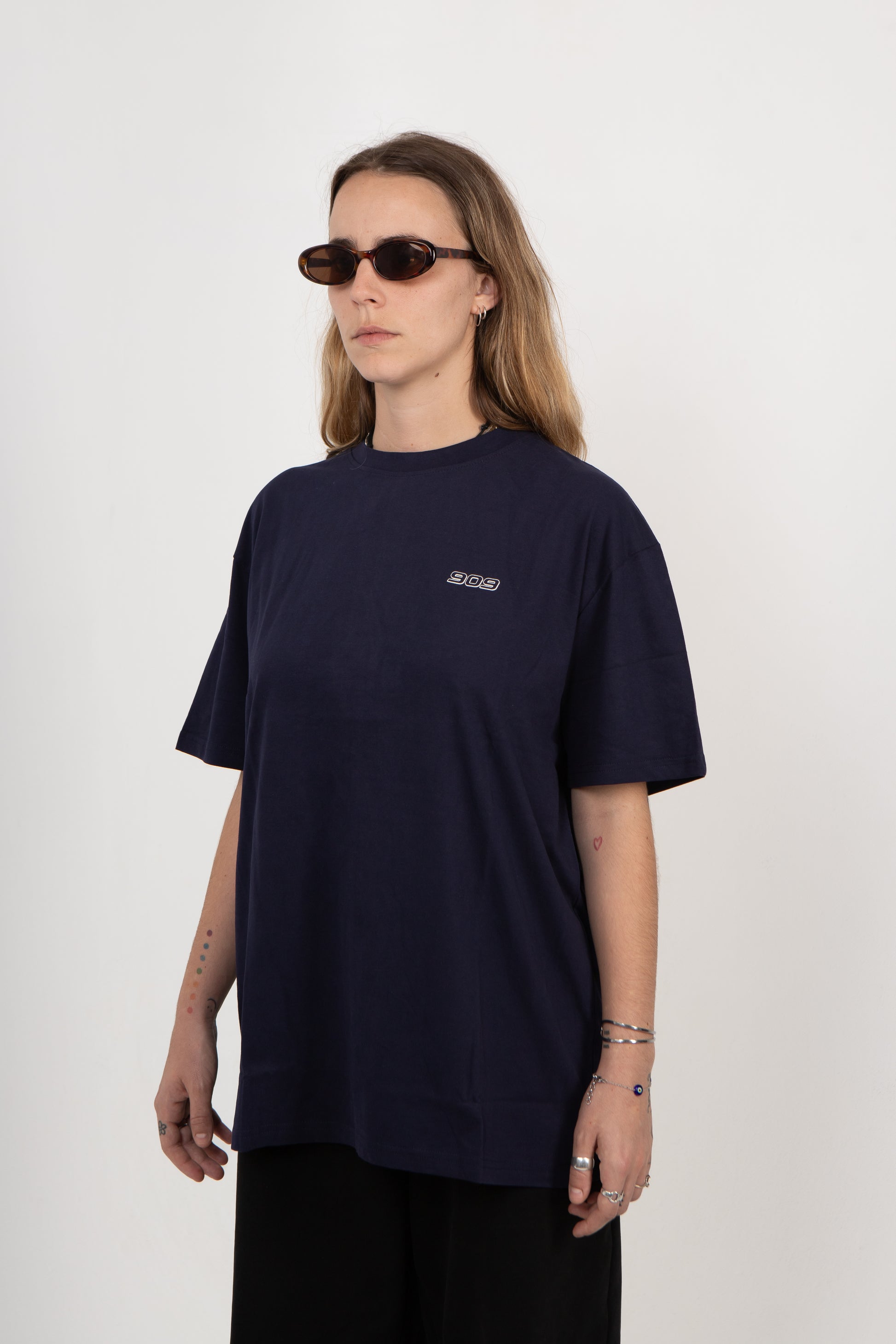 Person wearing a navy blue t-shirt with a logo on a white background