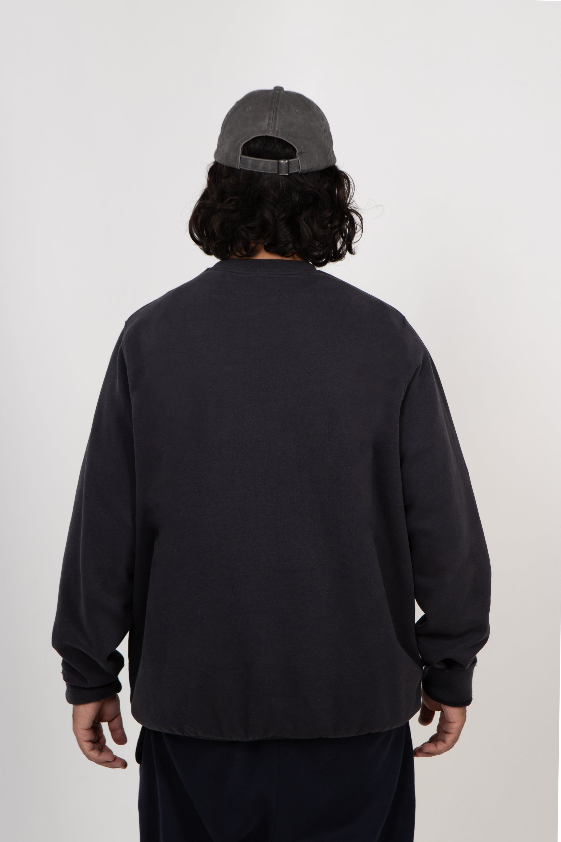 Person wearing a Navy sweatshirt and cap on a white background