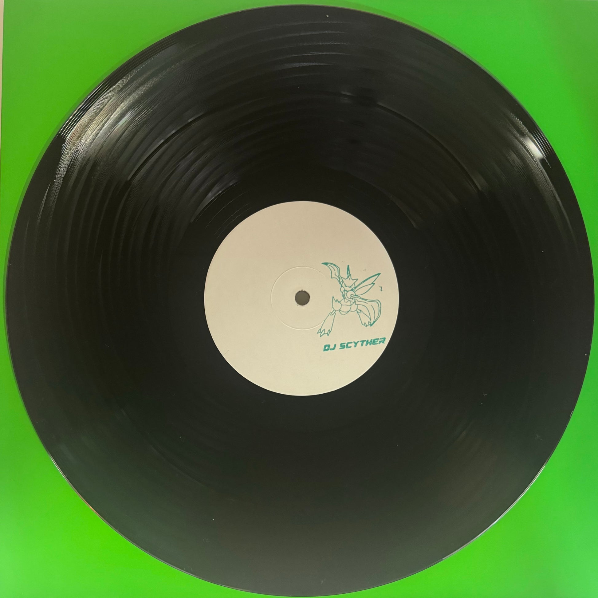A vinyl record with a green background, featuring a label with the text 'INSECTOID AUDIO' and an illustration of a Pokemon called scyther. The record appears to be black.