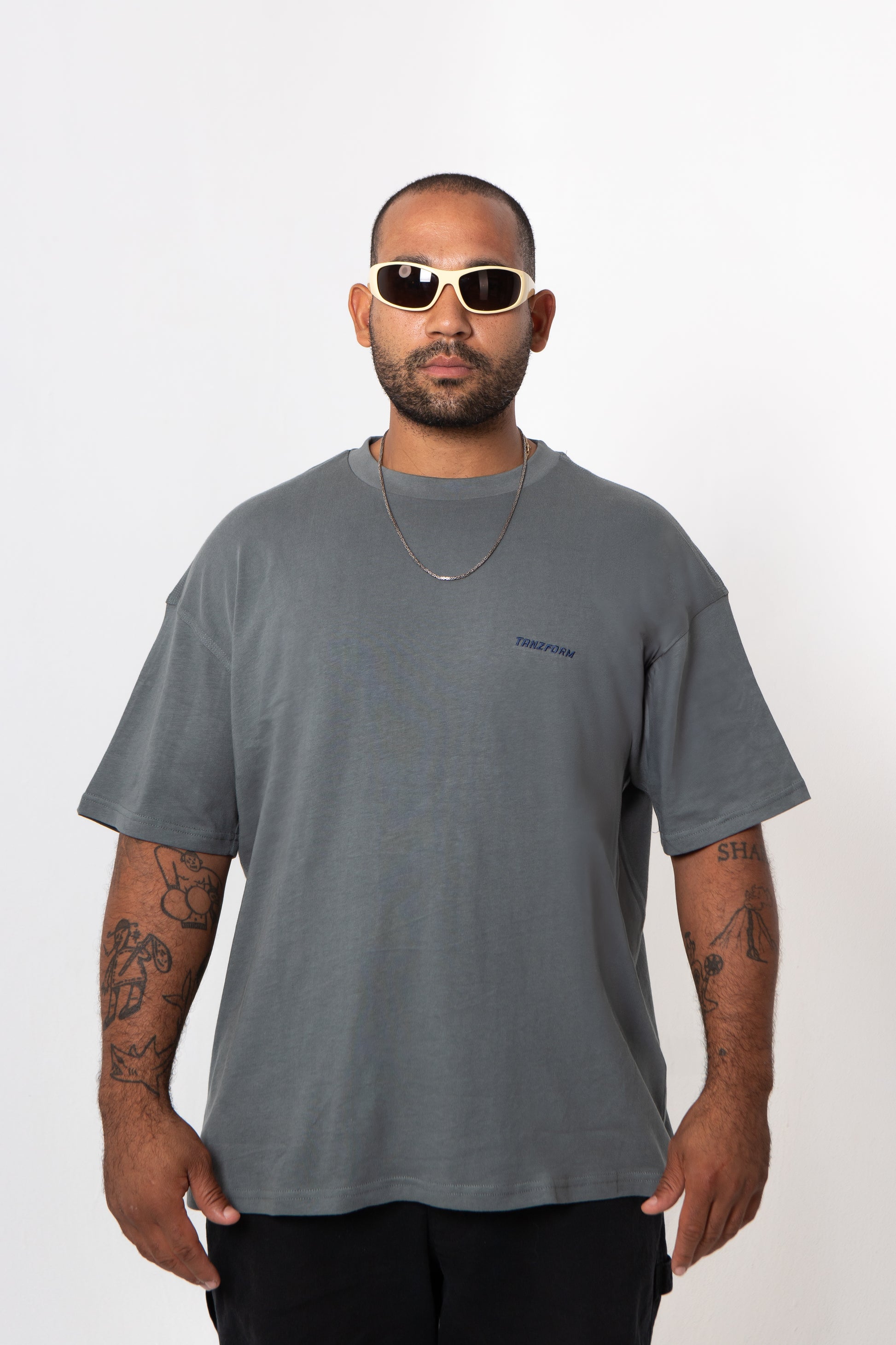 Man wearing a gray t-shirt and sunglasses on a white background