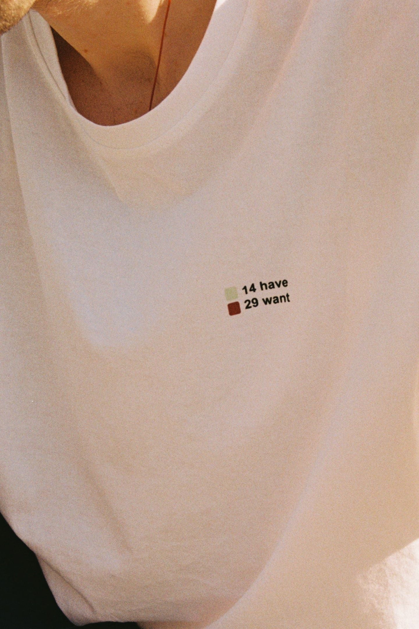 A person wearing a white short-sleeved t-shirt with a text graphic on the front.