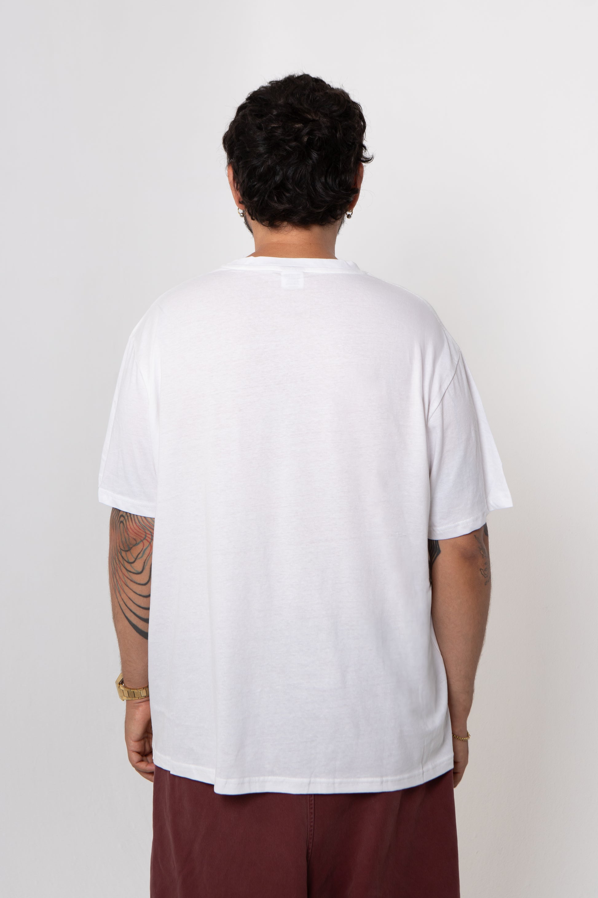 Person wearing a plain white t-shirt against a white background