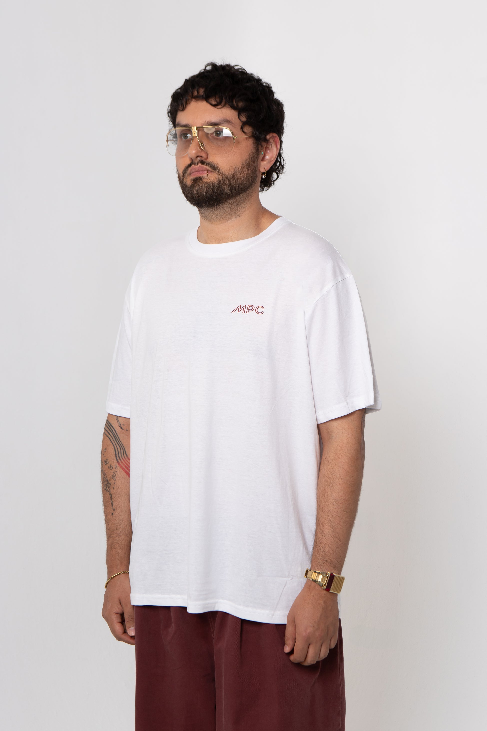 Man wearing a white t-shirt with a logo on a plain background