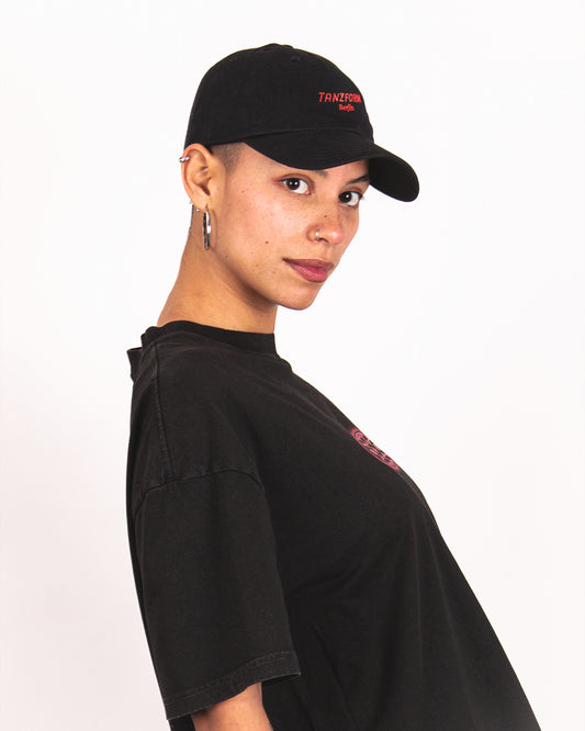 Person wearing a black cap and black t-shirt with red text on a white background
