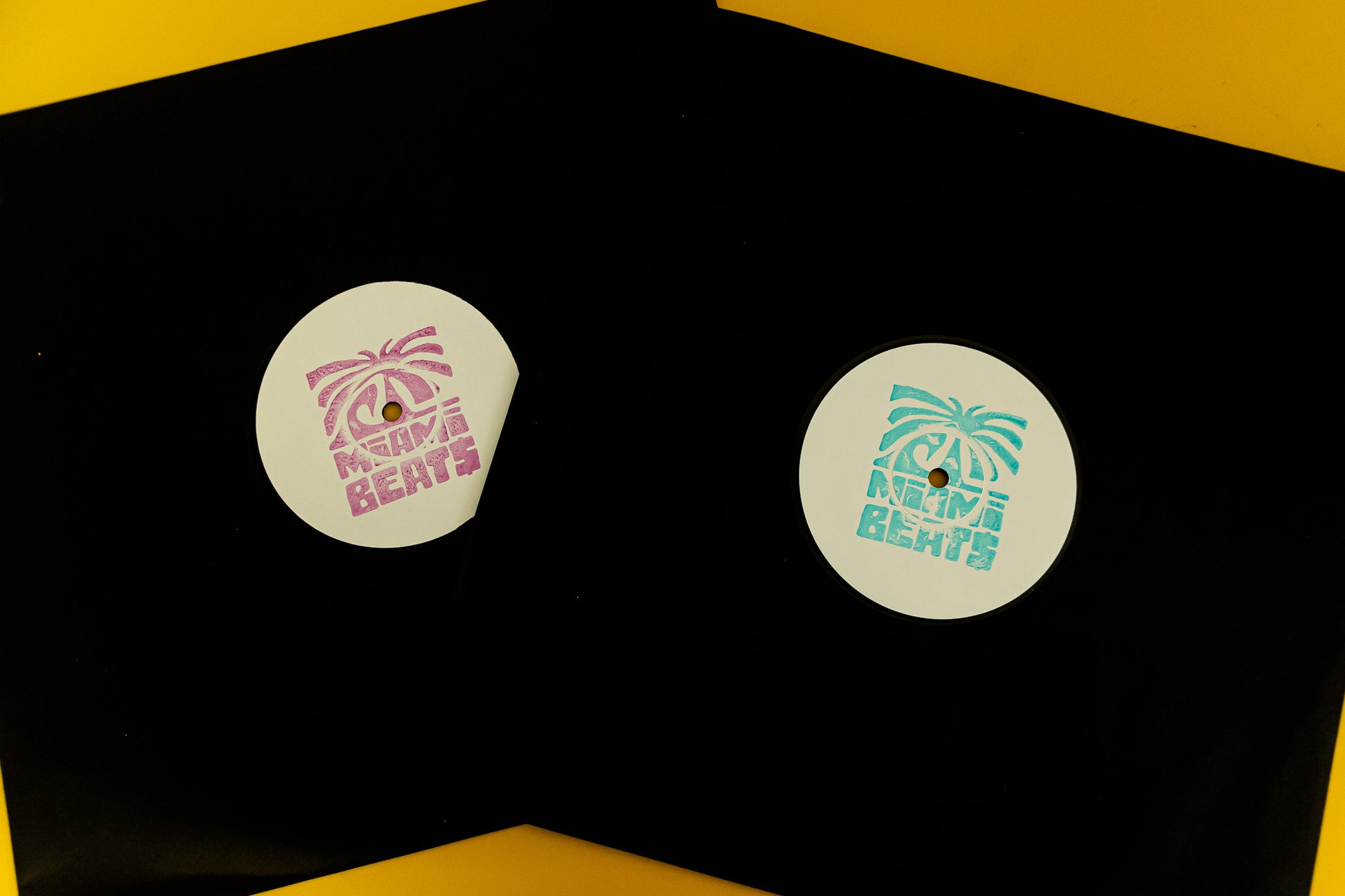 Two vinyl records with labels on a black surface