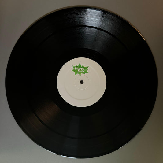 A black vinyl record with a label featuring the text 'STAMPO' and a green leaf logo in the center.