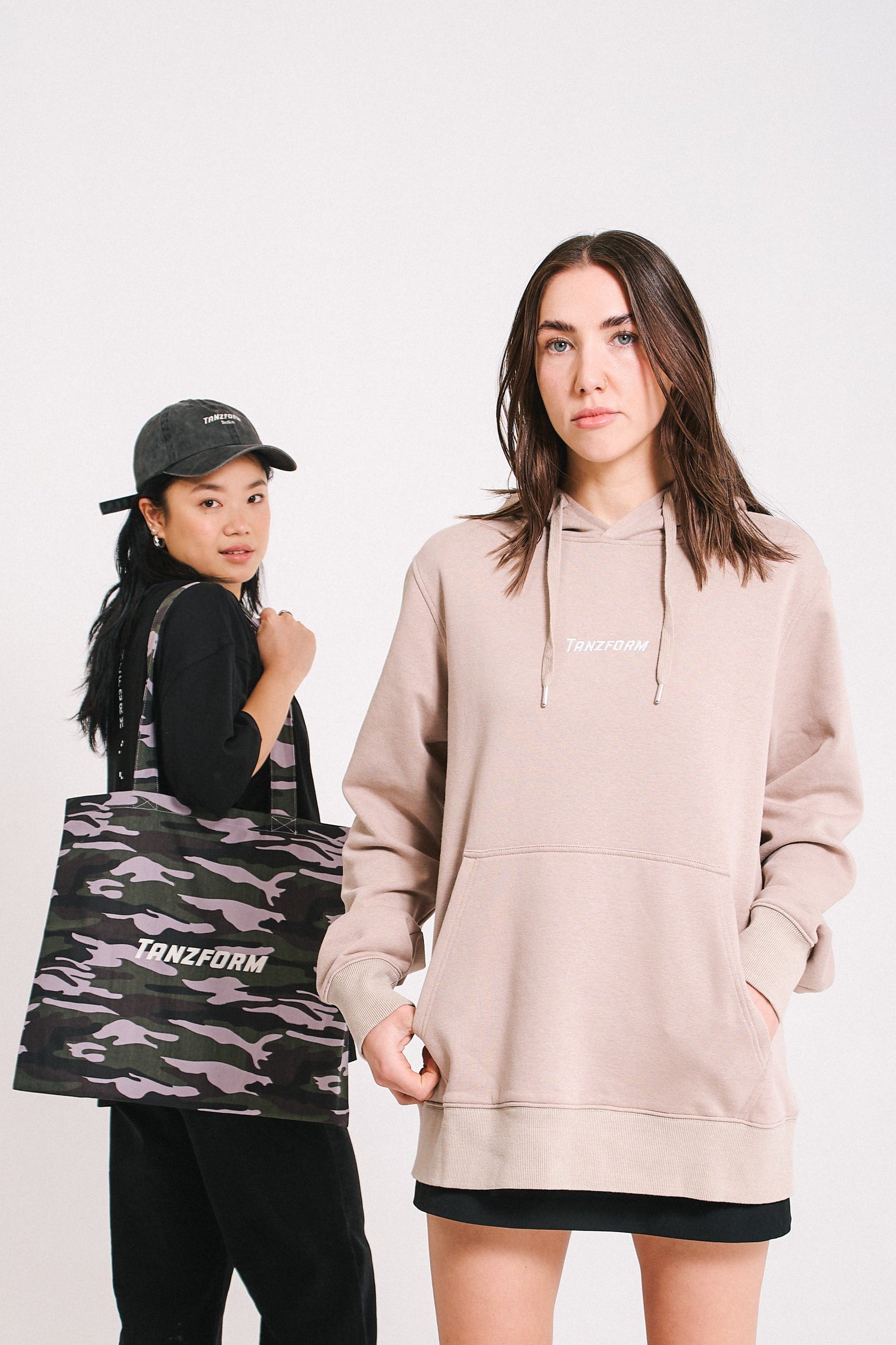 People wearing the camo tote bag with a pink sweatshirt Tanzform.