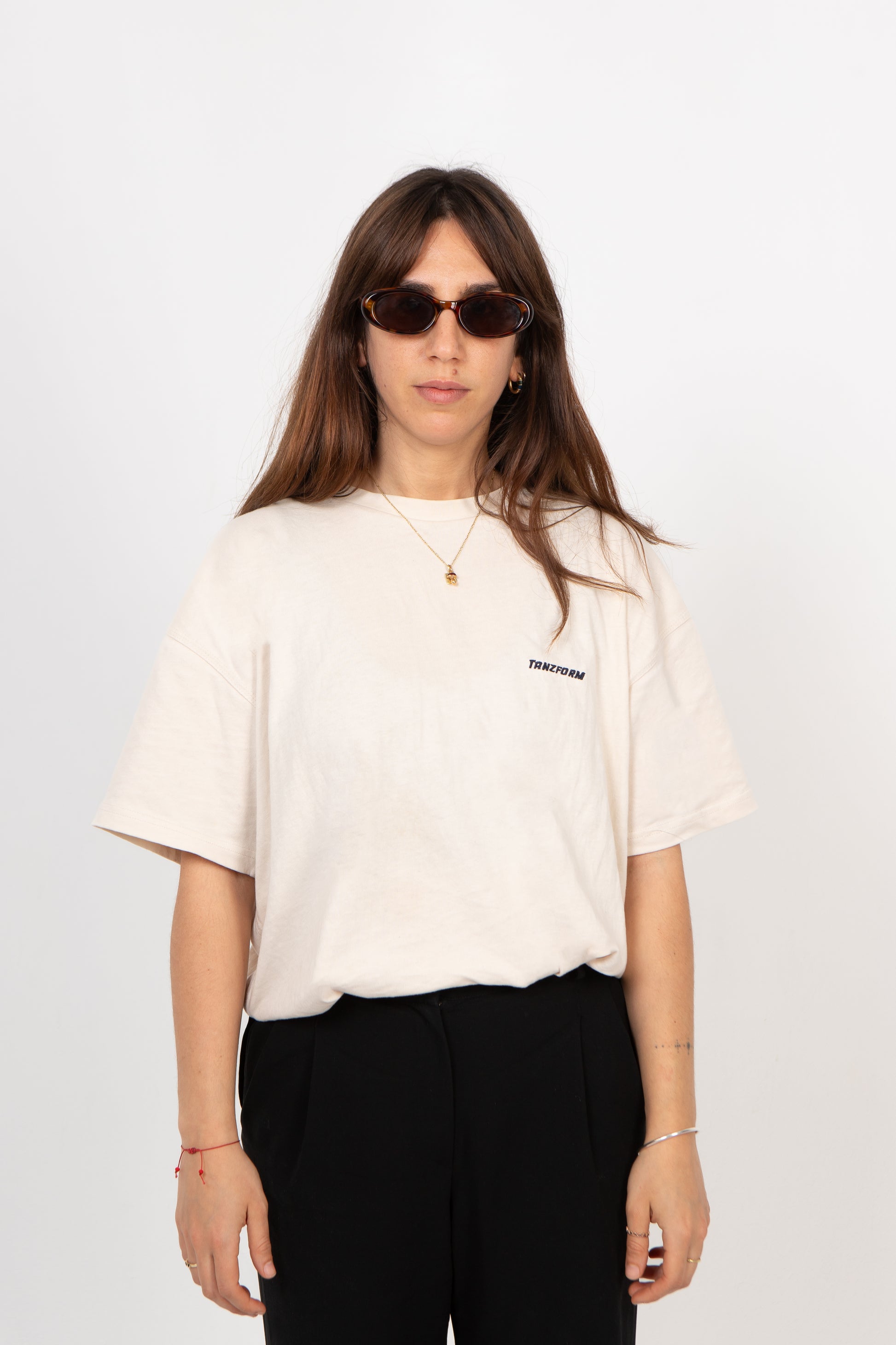 Person wearing a white t-shirt with a logo and sunglasses on a white background