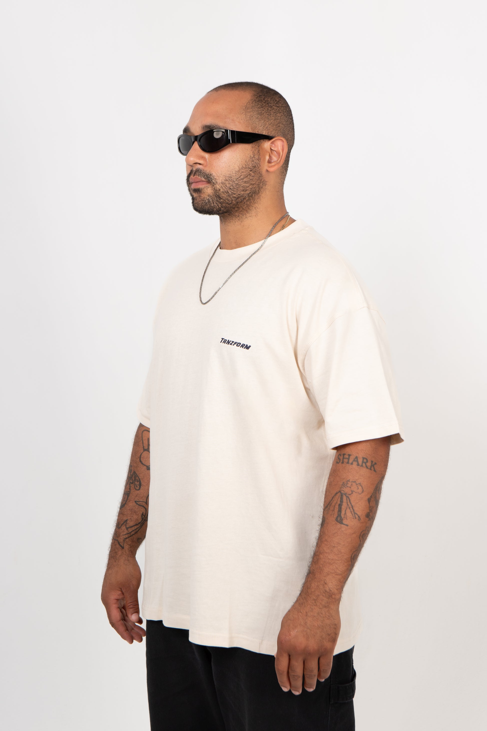 Man wearing a white t-shirt with text on a plain background