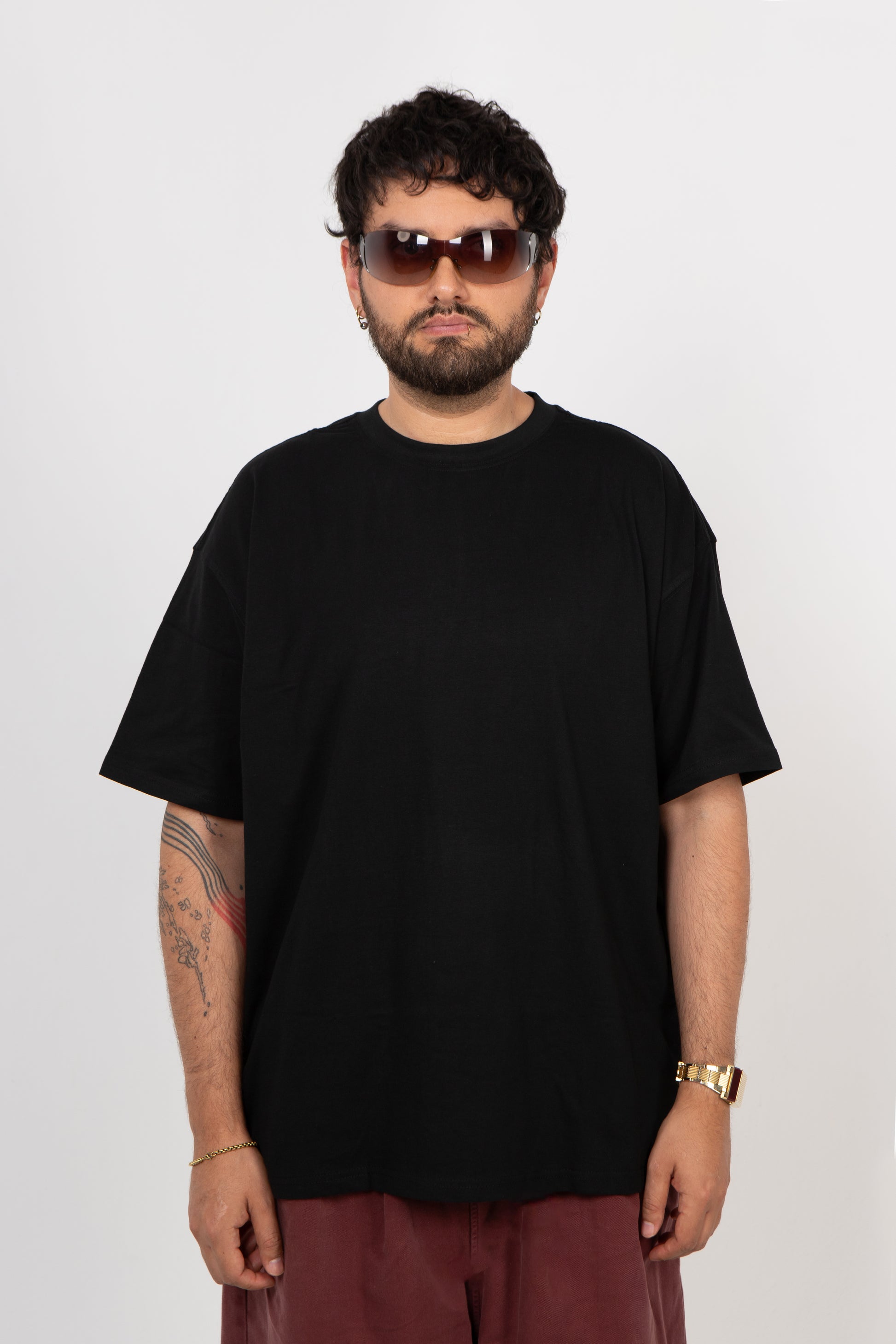 Person wearing a black t-shirt and sunglasses on a white background