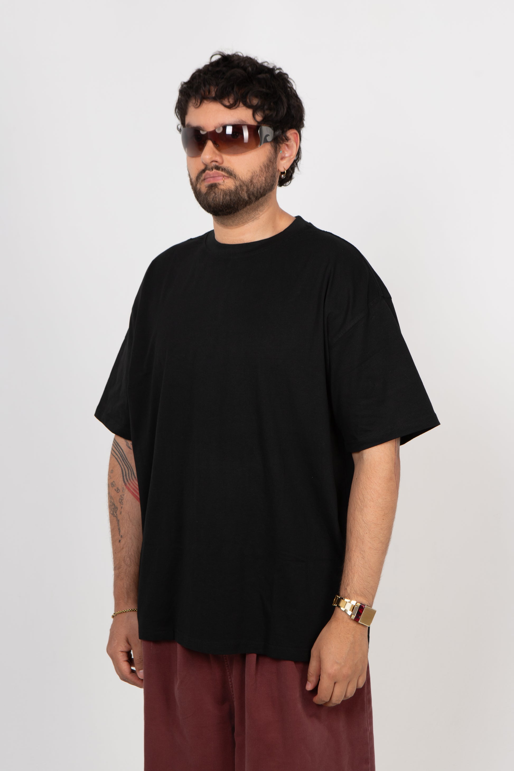Man wearing a black t-shirt and sunglasses on a white background