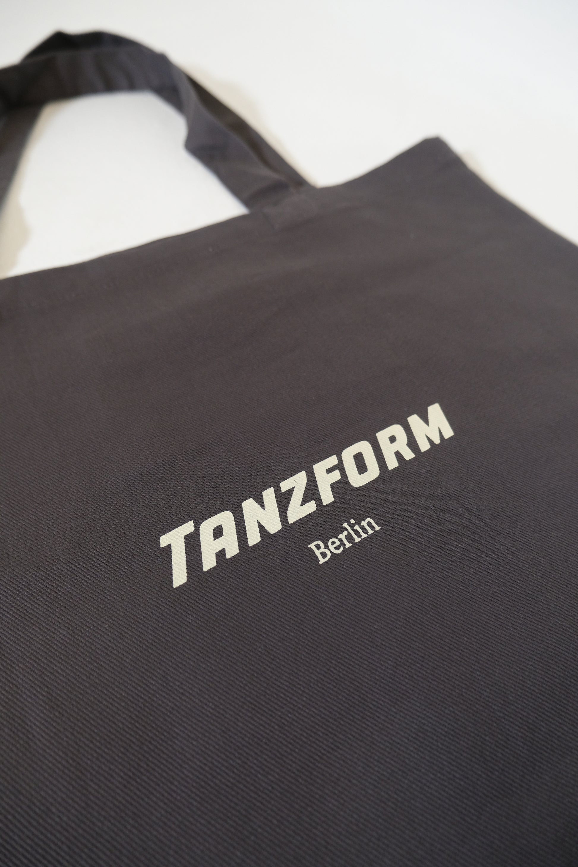 Grey bag with 'TANZFORM Berlin' text on a white background