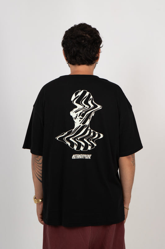 Person wearing a black t-shirt with a white graphic design on the back against a plain background