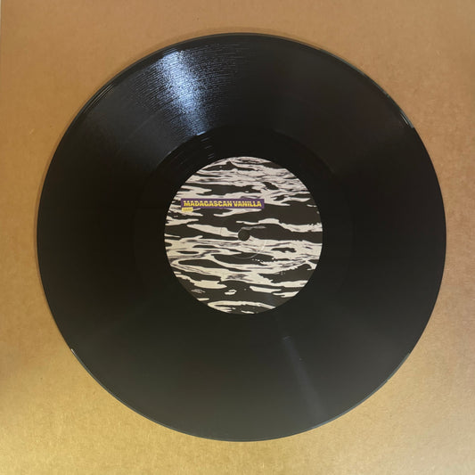 A black 10-inch vinyl record labeled 'TEN001 // Tjaqu - The Doorsmith Chronicles EP' with a white and black design in the center.