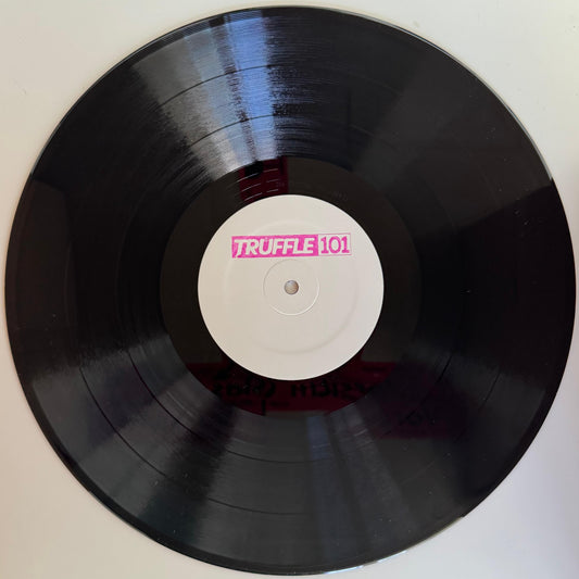 A vinyl record labeled 'TRUFFLE101' with a white label in the center and pink text.