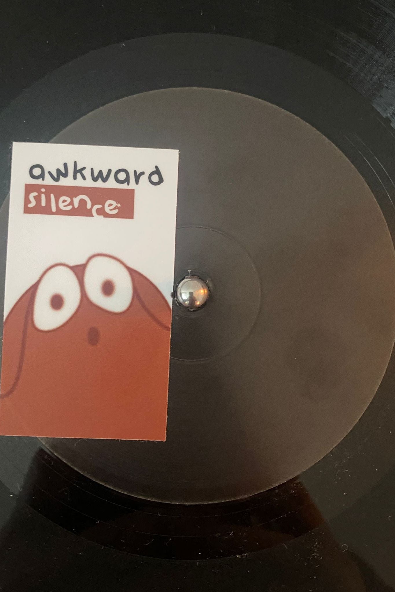 vinyl record black label with a sticker awkward silence