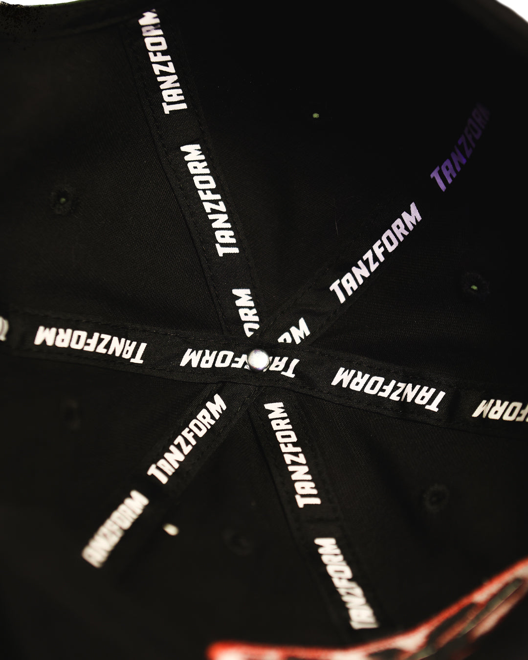 Black cap with 'TANZFORM' branding on the strap