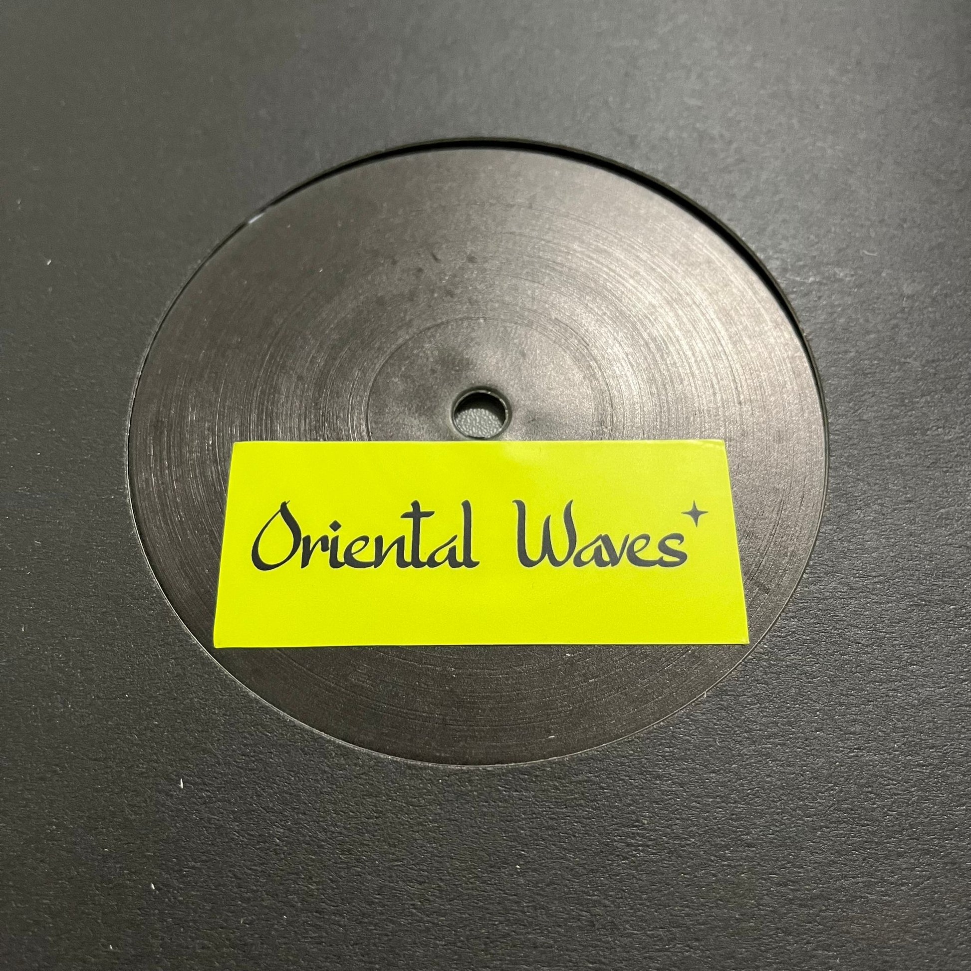 Vinyl record with a yellow label reading 'Oriental Waves' on a black background