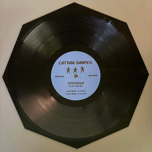 A black vinyl record with a label that reads 'Cutting Shapes' and 'Oshana - Play Me EP