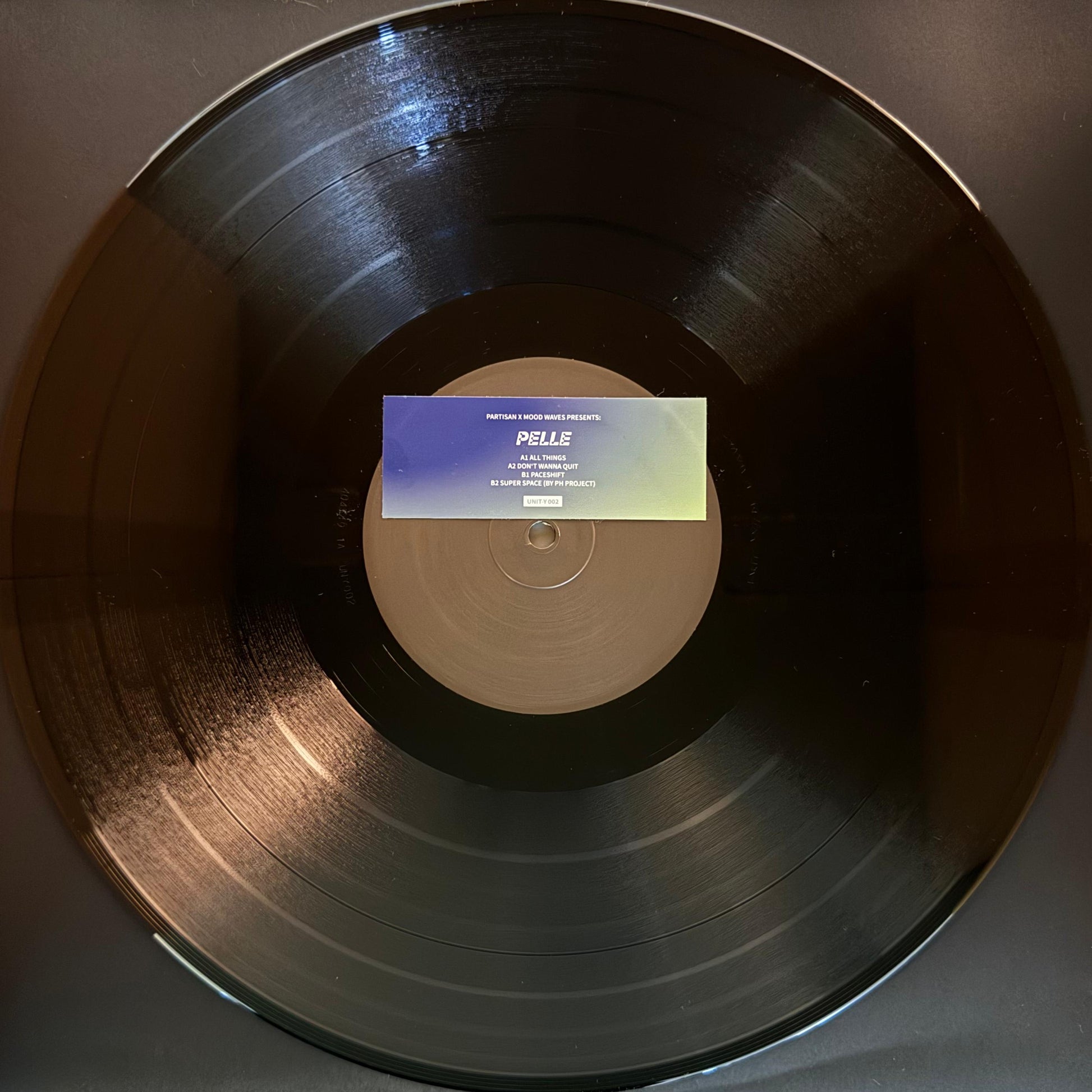 A vinyl record labeled 'Pelle' predominantly in a black color with a central label.