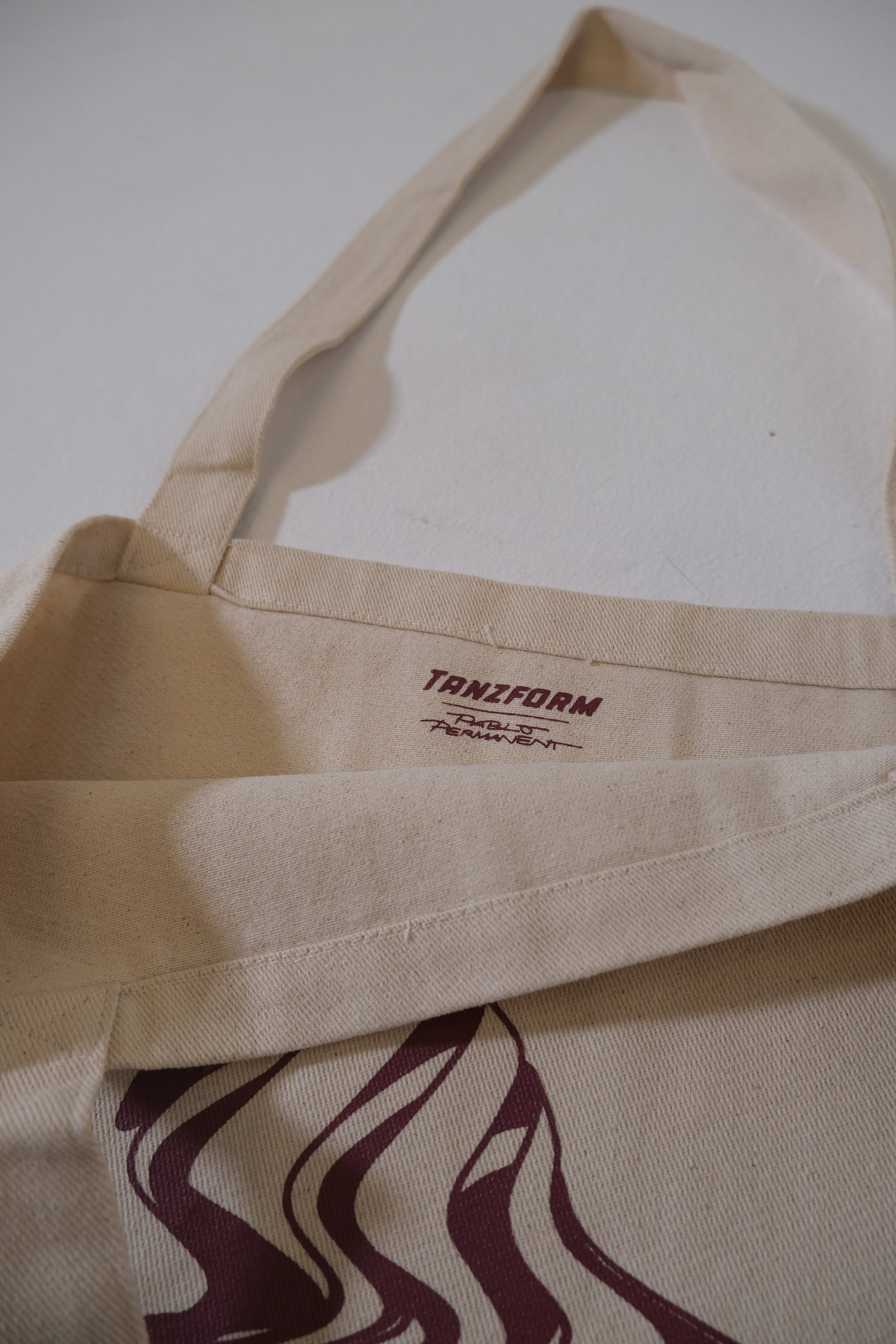 Beige tote bag with 'Tanizform' branding on a white background