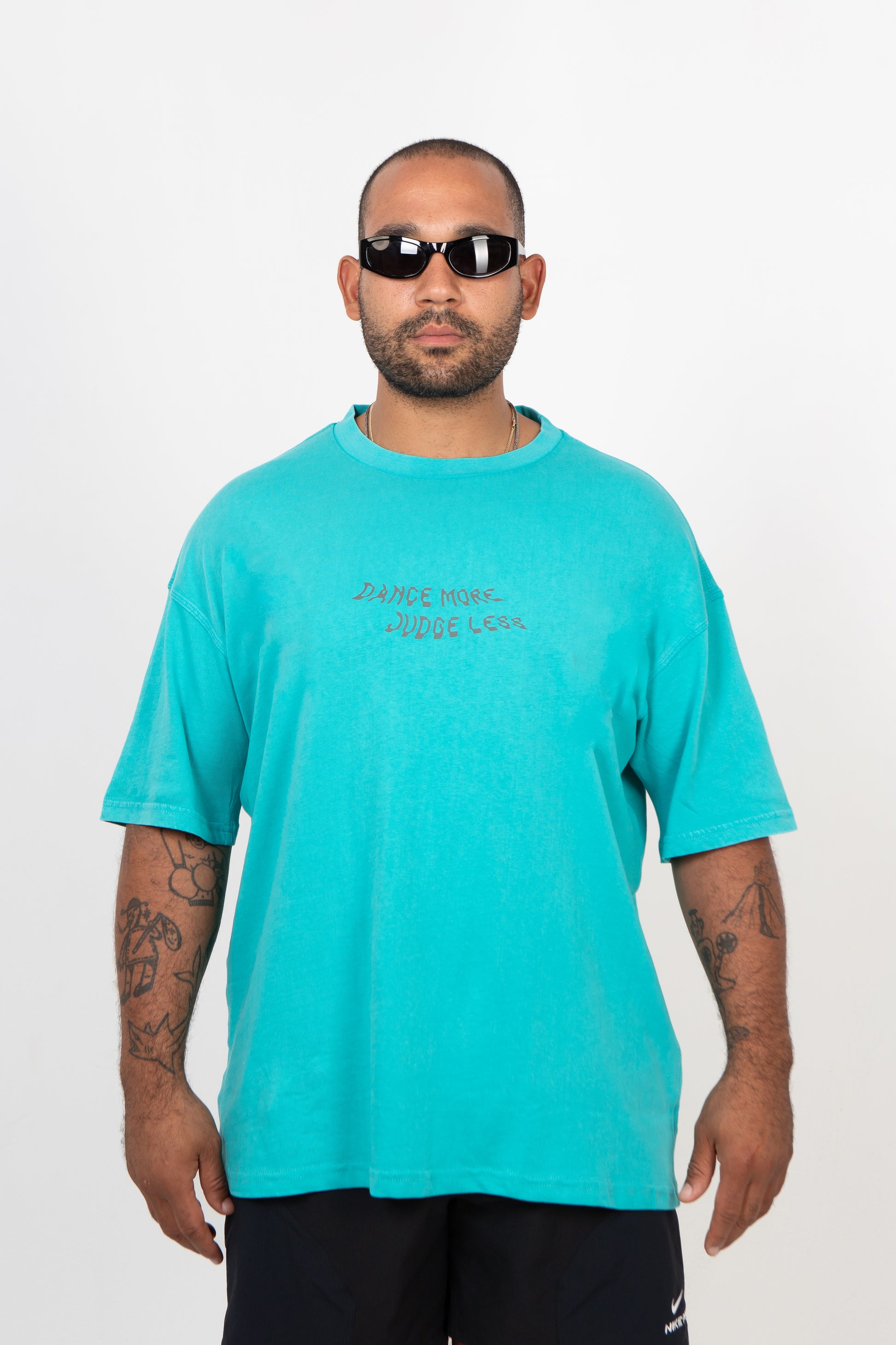 Man wearing a turquoise t-shirt with text on a white background