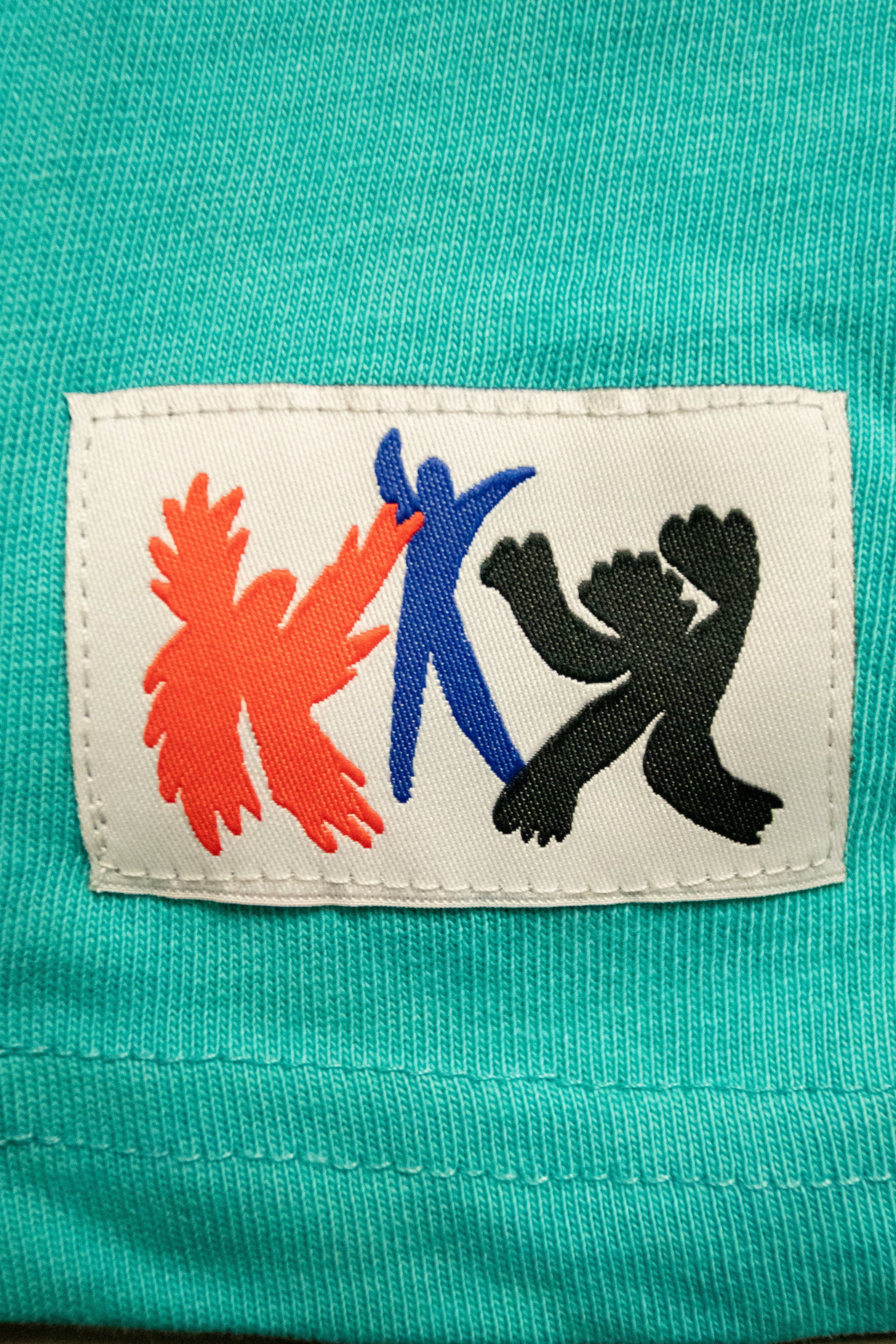 Close-up of a label with colorful symbols on a teal fabric background