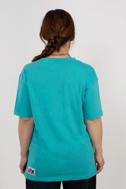 Person wearing a teal t-shirt with a small logo on the back.