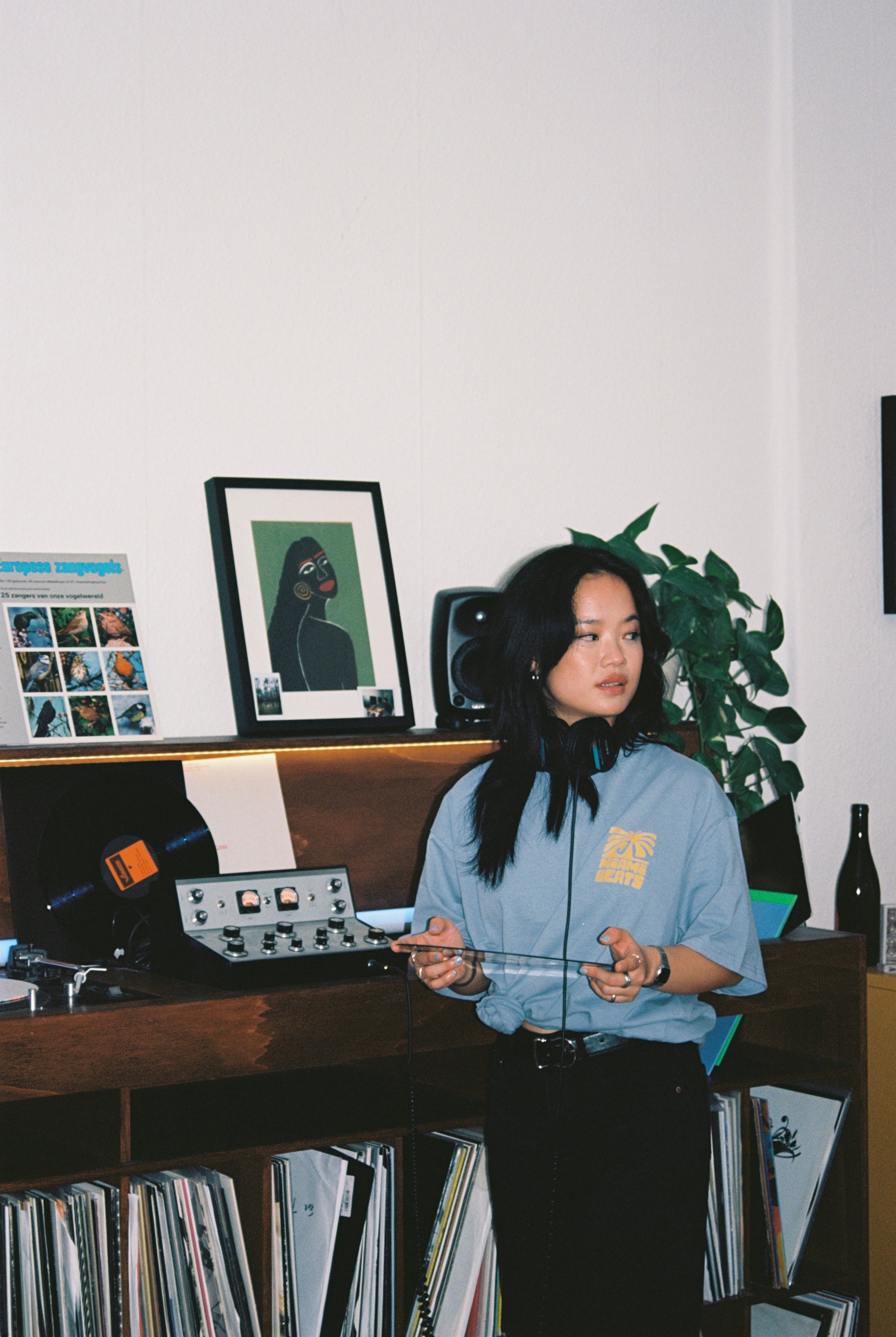 Helly wearing a miami beats tshirt and having a tanzform record in her hand while standing in front of a dj booth