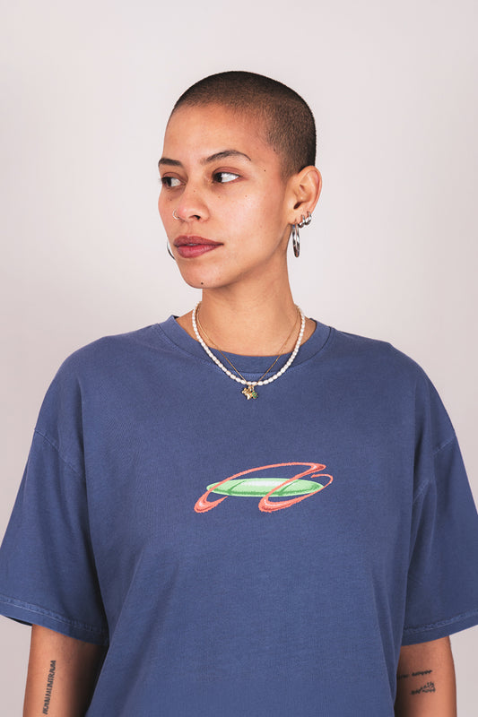 Person wearing a blue t-shirt with a colorful graphic design on a plain background