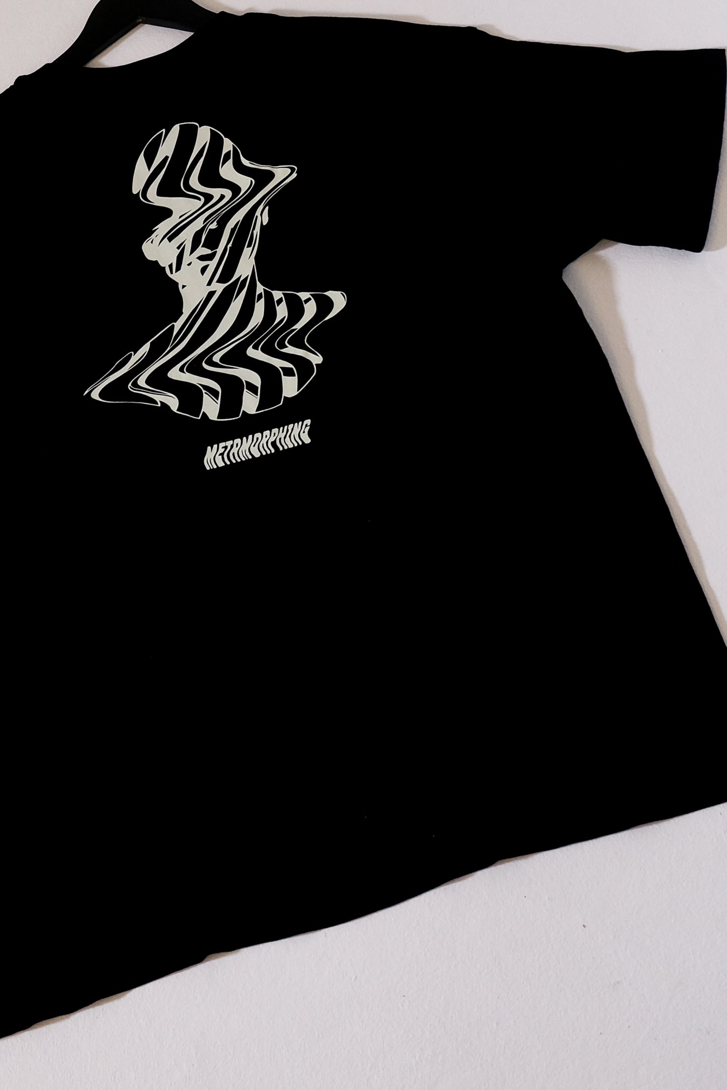 Black t-shirt with a white graphic design on a white background