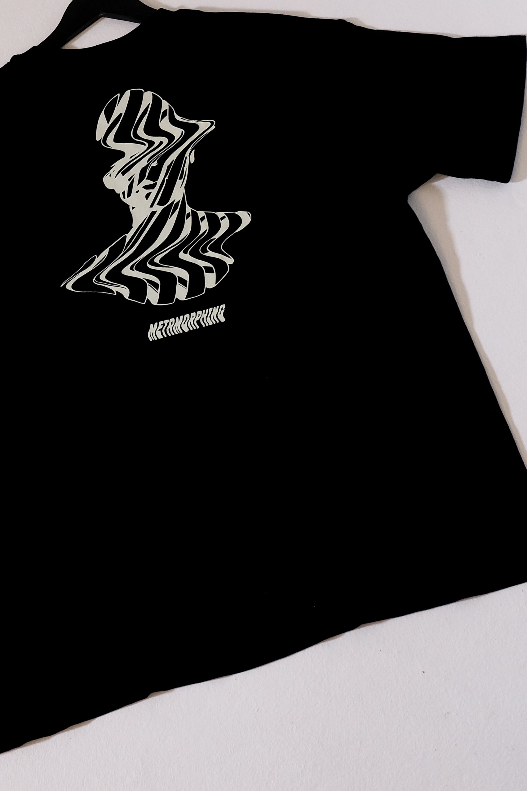 Black t-shirt with a white graphic design on a white background