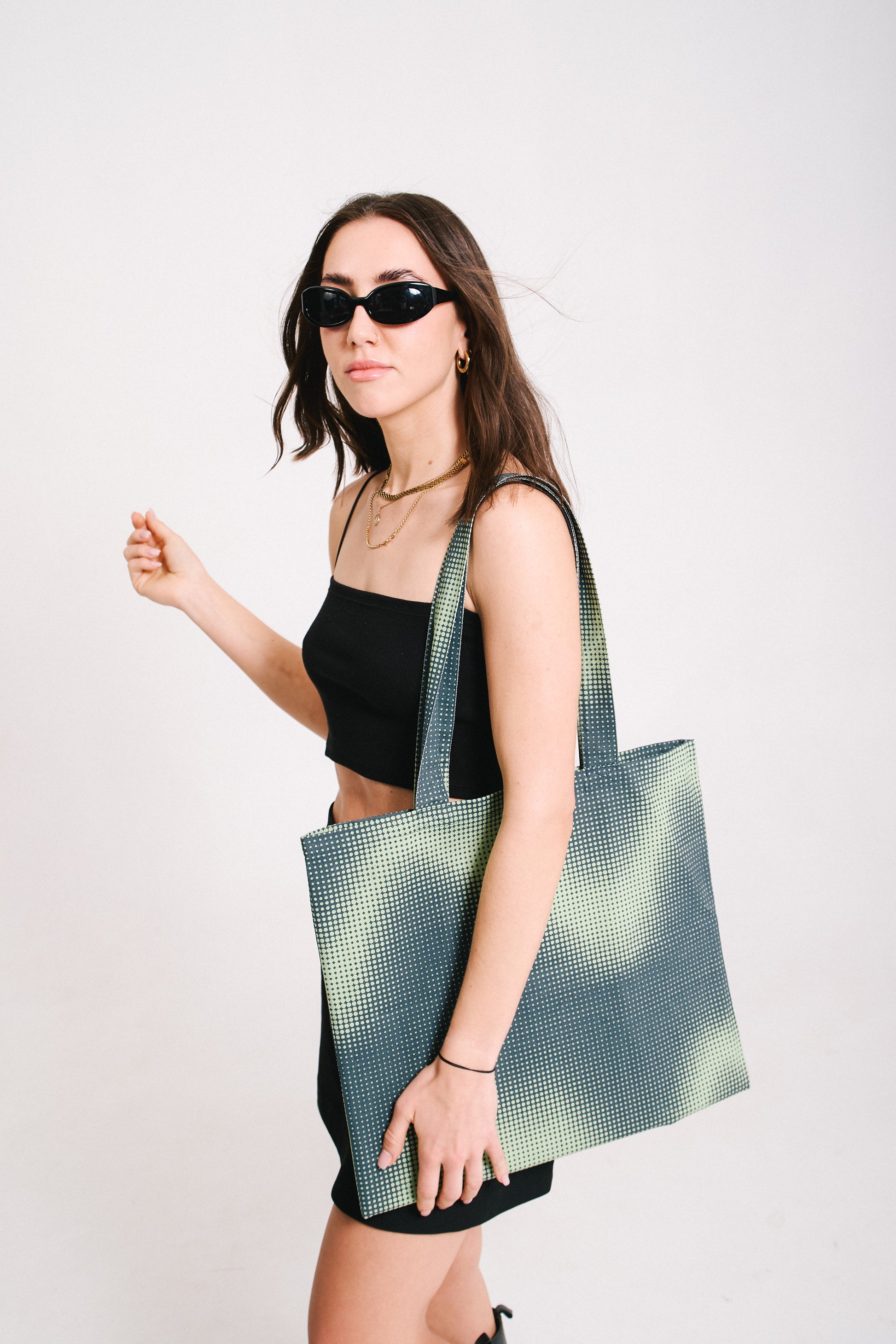 model wearing a tote bag and sunglasses