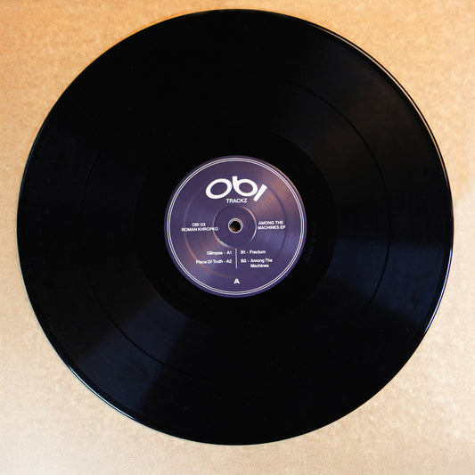 Black vinyl record with a purple label on a beige background