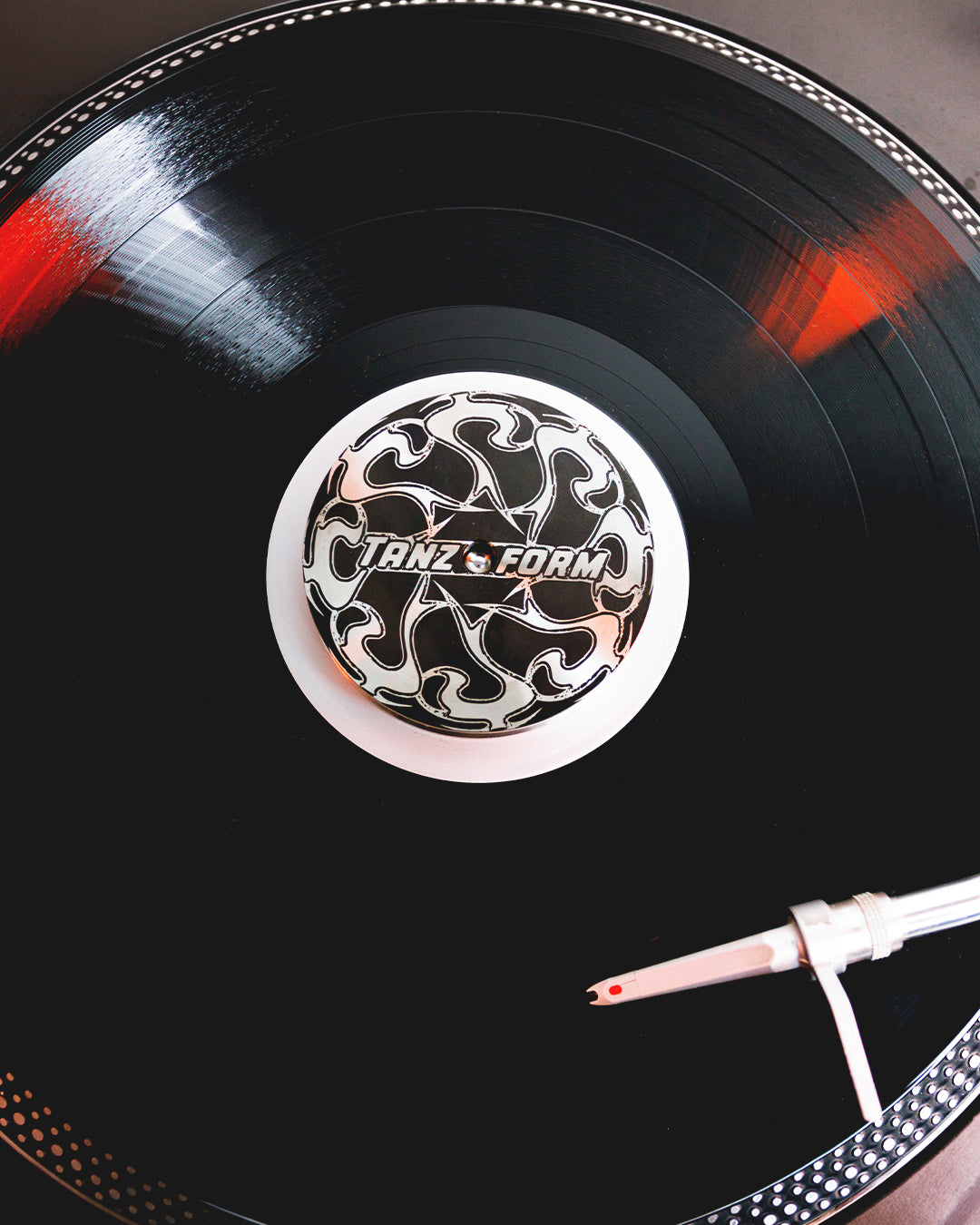 Close-up of a vinyl record with a stylus on a dark surface